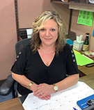Robbie Bates, personal lines account manager, wearing a black shirt at a brown desk at V.R. Williams and Company in Winchester, TN