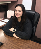 Gabrielle Powers, personal lines account manager, wearing a black sweater at a brown desk at V.R. Williams and Company in Winchester, TN